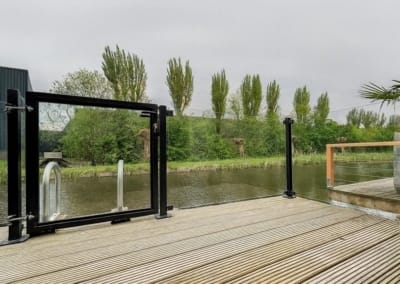 Glazen balustrade vlonder windscherm met looppoort kindveilig | Consepto Hekwerk